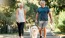 a man and a woman walking a dog on a leash