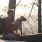 a man with a backpack sitting on a log with a dog
